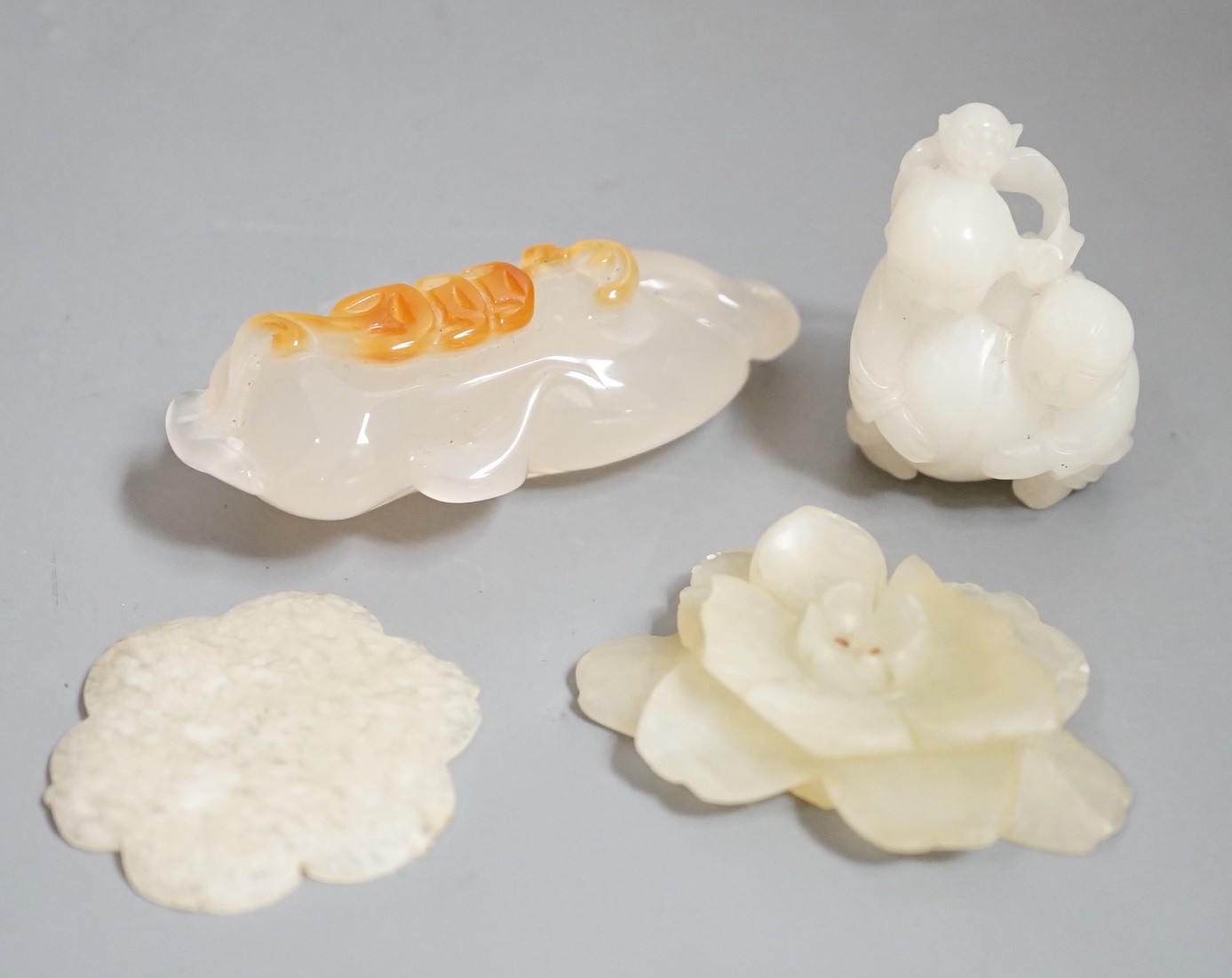Two Chinese jade flower head carvings, Ming dynasty, a white Jade group of two boys and a monkey and an agate carving (4)